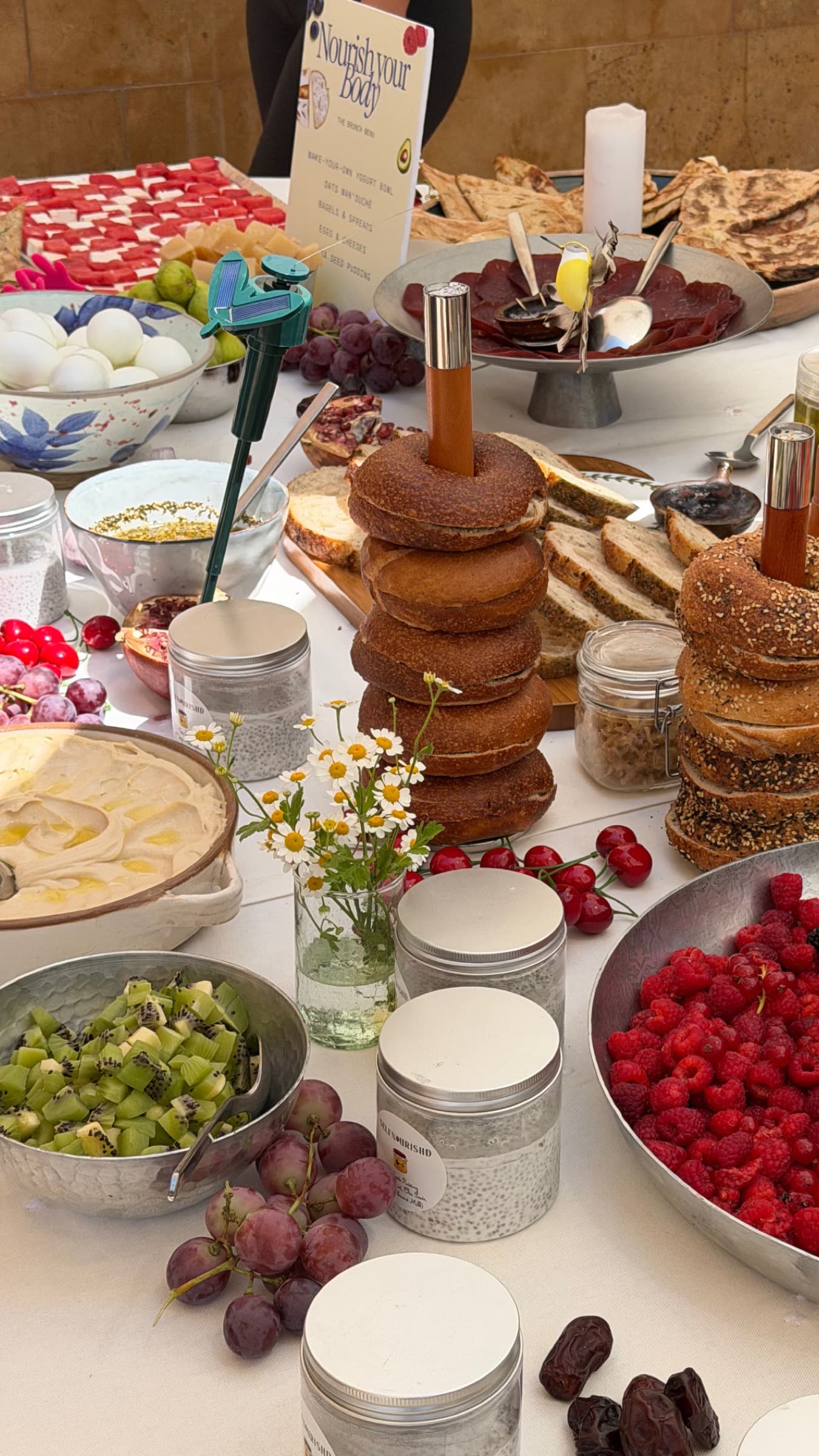 Long table with the printed brunch menu, bagel towers and chia jars